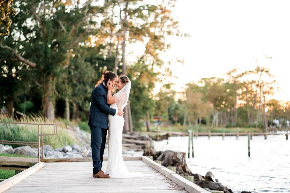 Couple poses at wedding on boardwalk.