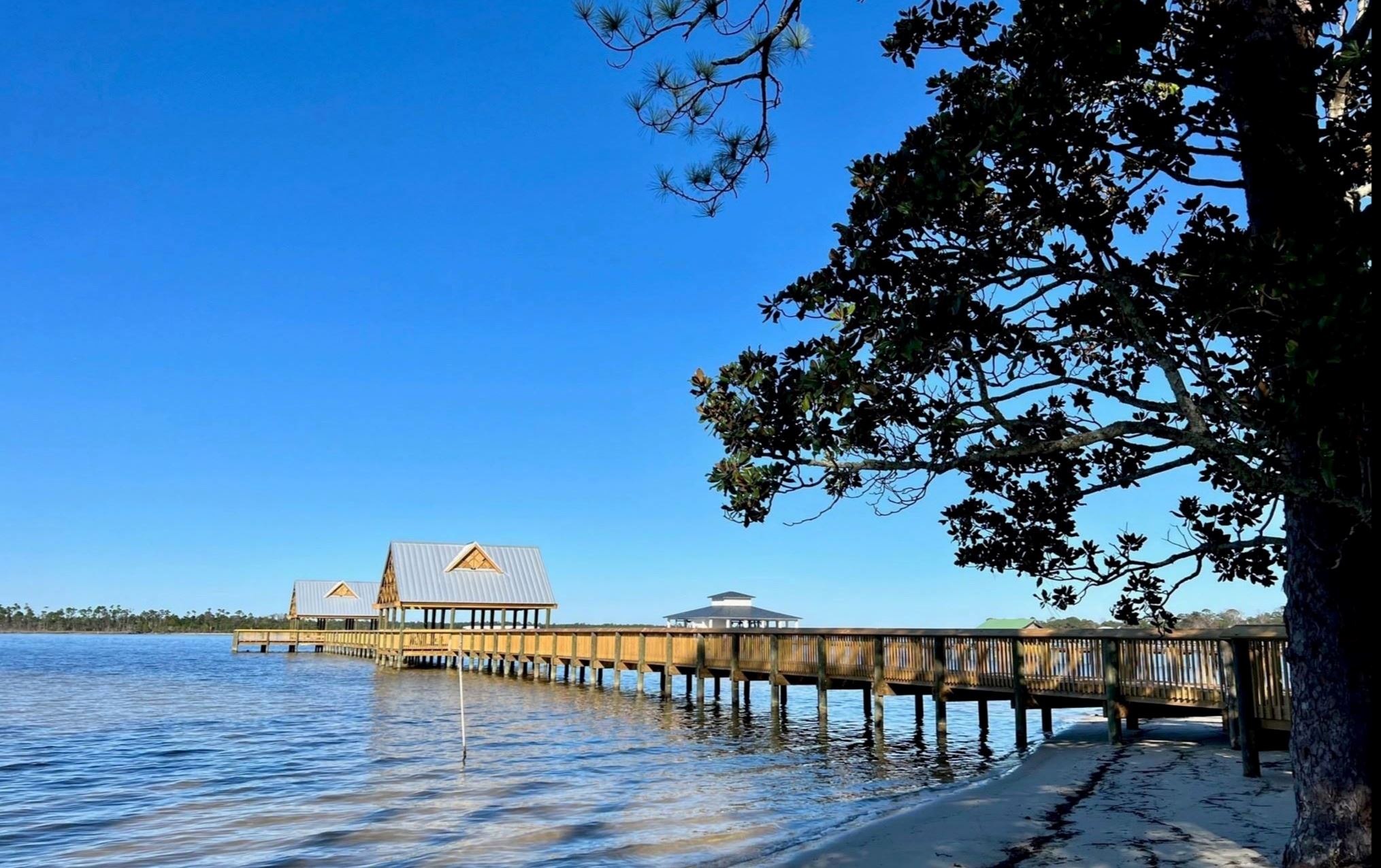 Orange Beach Waterfront Park Pier juts out onto Wolf Bay on a clear sunny day