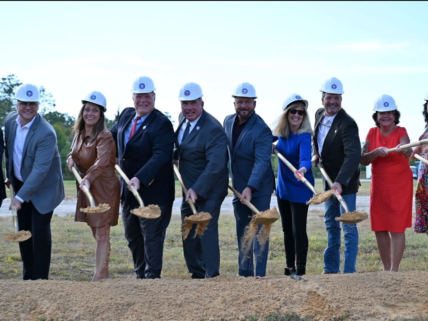 City, state and school officials sling dirt with gold shovel at the Orange Beach Athletic Complex gr