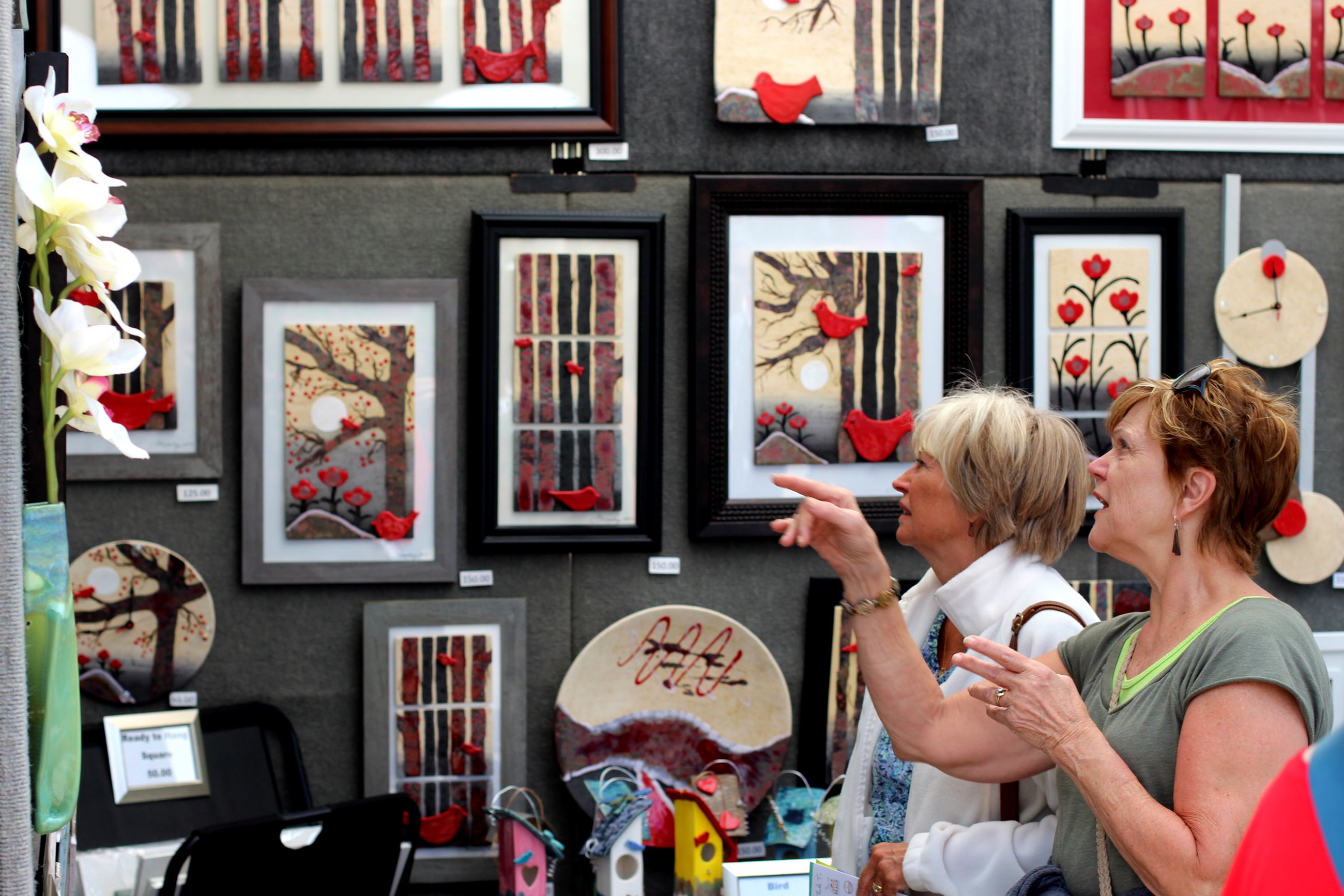 Patrons looking at art in booth display