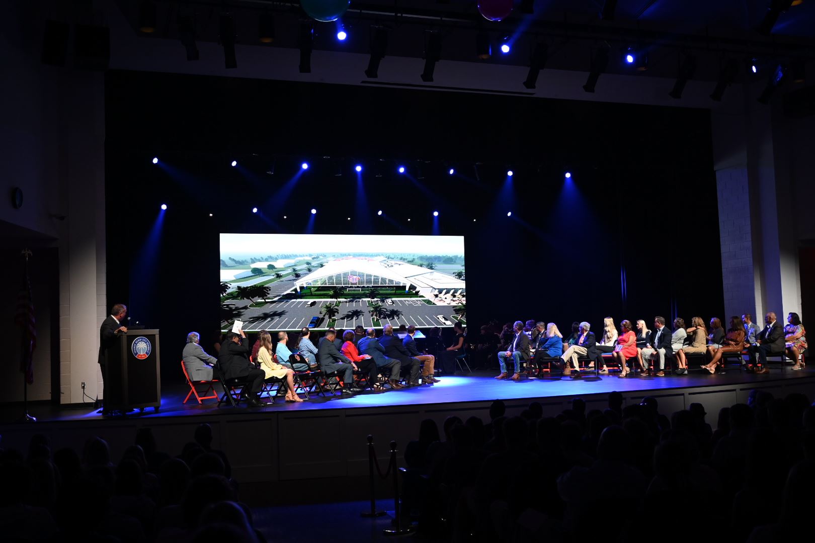 Full stage at the Orange Beach Performing Arts Center with officials looking at a presentation