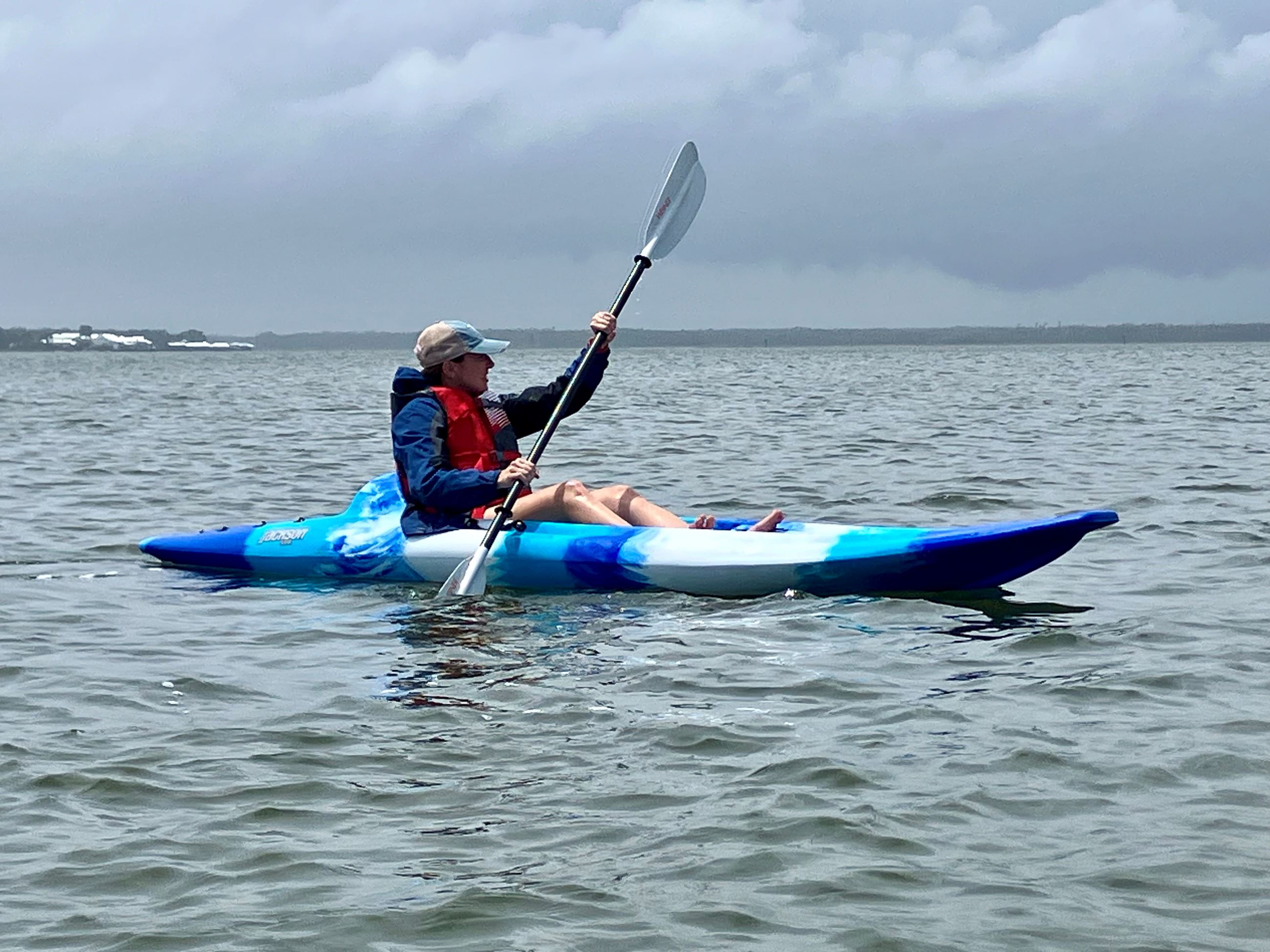 A person kayaks on Wolf Bay at the Orange Beach Wind and Water Learning Center