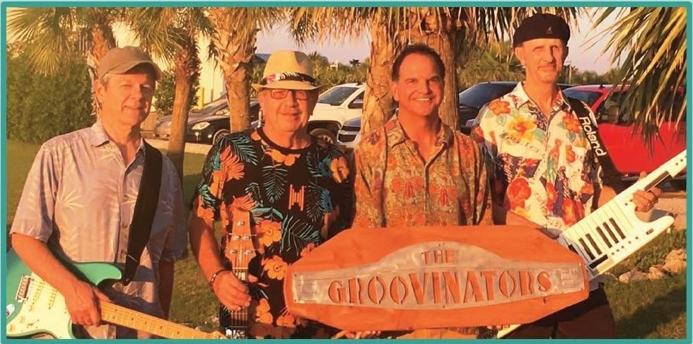 group stands with instruments and sign for picture